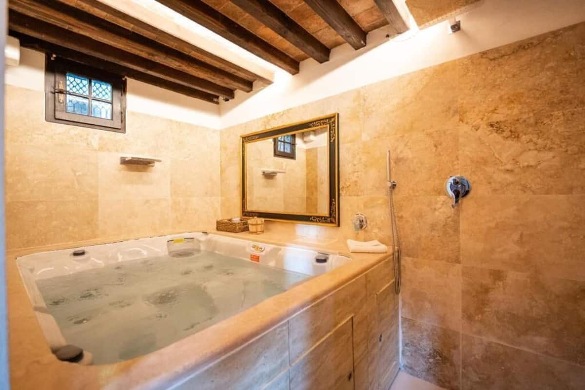 suite spa bath | bathroom | bathtub, rainfall showerhead, hair dryer, slippers