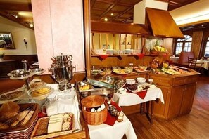 En buffé med ett varierat utbud av mat och serveringsredskap.