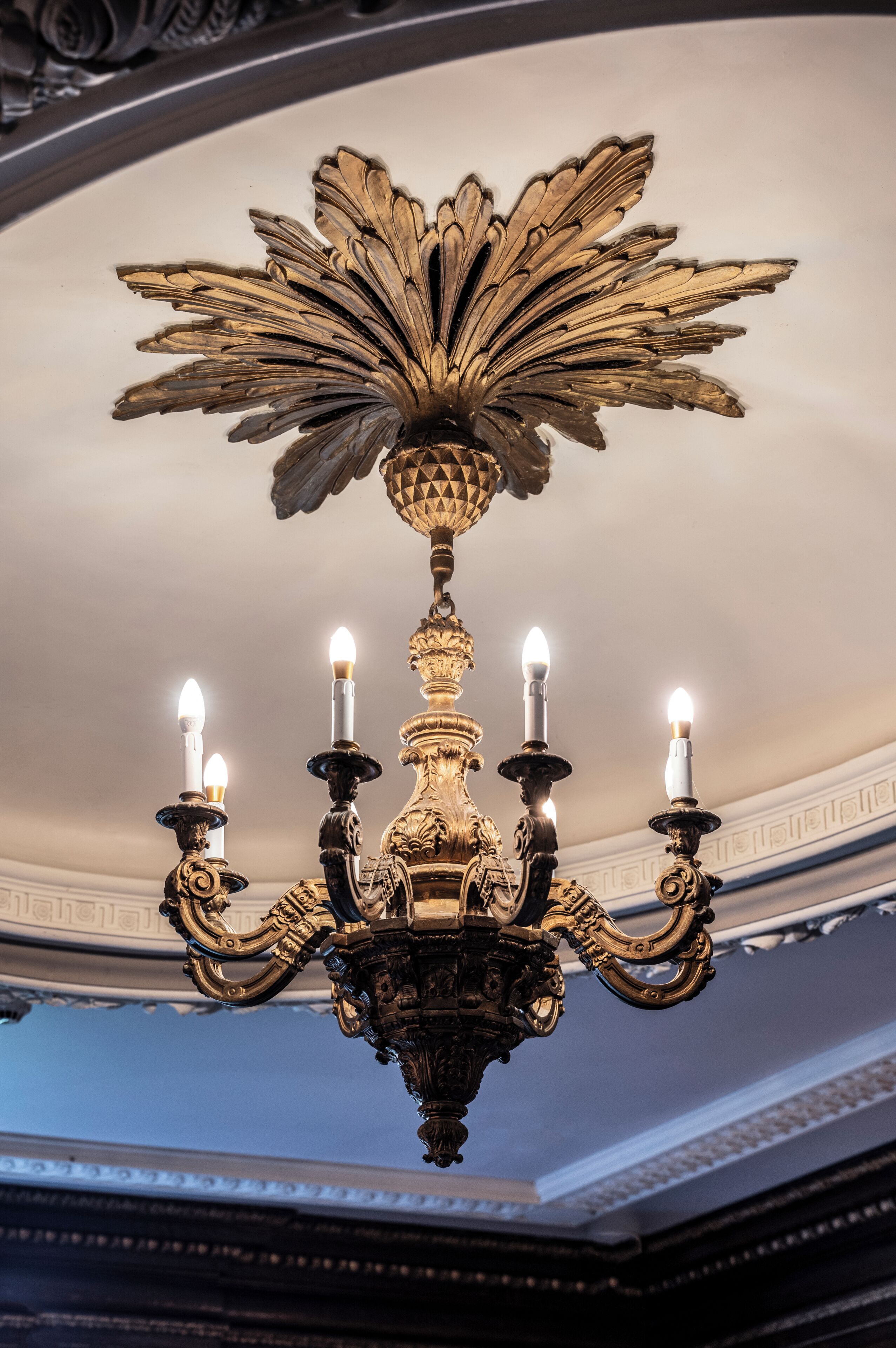 A chandelier with multiple candle-like lights and ornate decorations.