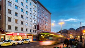 A hotel with multiple floors, a prominent entrance, and a tram passing by. - Leonardo Hotel Frankfurt City Center (Frankfurt)