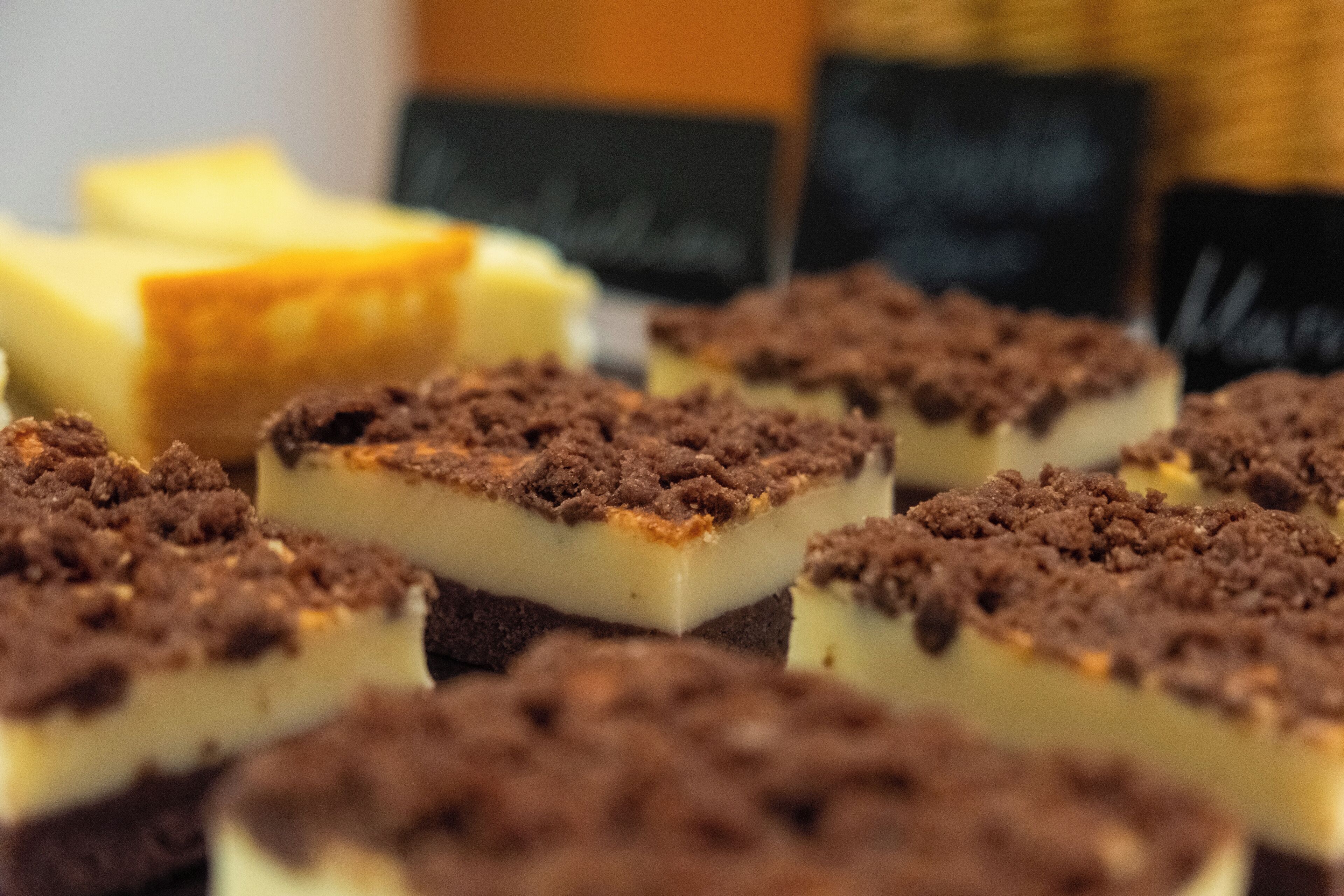 A close-up of dessert bars with a crumbly topping, arranged on a tray.