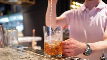 Ein Barkeeper gießt ein Getränk ein.
