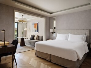 A modern hotel room with a large bed, a desk, a chair, and a sofa. - Electra Palace Athens (Athens)