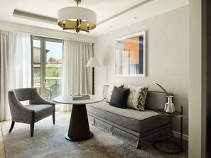 A modern living room with a sofa, armchair, round table, and a floor lamp. - Electra Palace Athens (Athens)