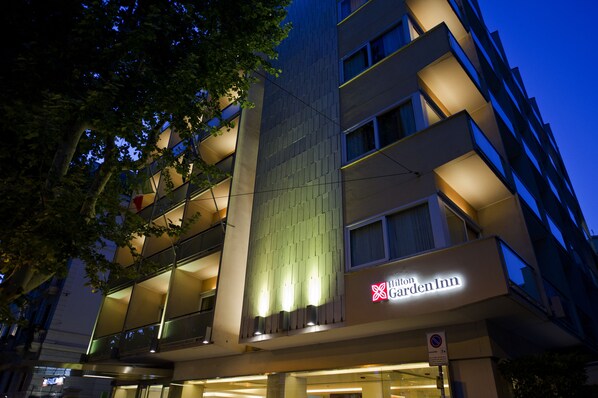 Un hôtel à plusieurs étages, doté d’une façade moderne, d’une enseigne lumineuse et de balcons.