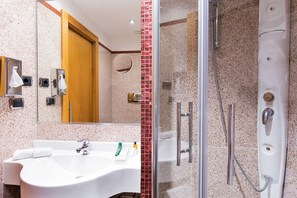 A bathroom with a sink, mirror, and shower. - Hilton Garden Inn Rome Claridge (Rome)