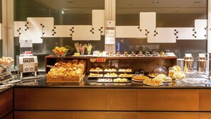 A buffet counter with various food items and a coffee machine. - Hilton Garden Inn Rome Claridge (Rome)