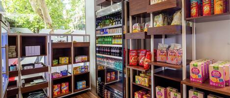 A store with wooden shelves stocked with various products including snacks, beverages, and packaged goods.