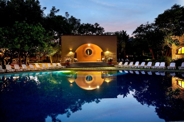 Una piscina al aire libre, tumbonas