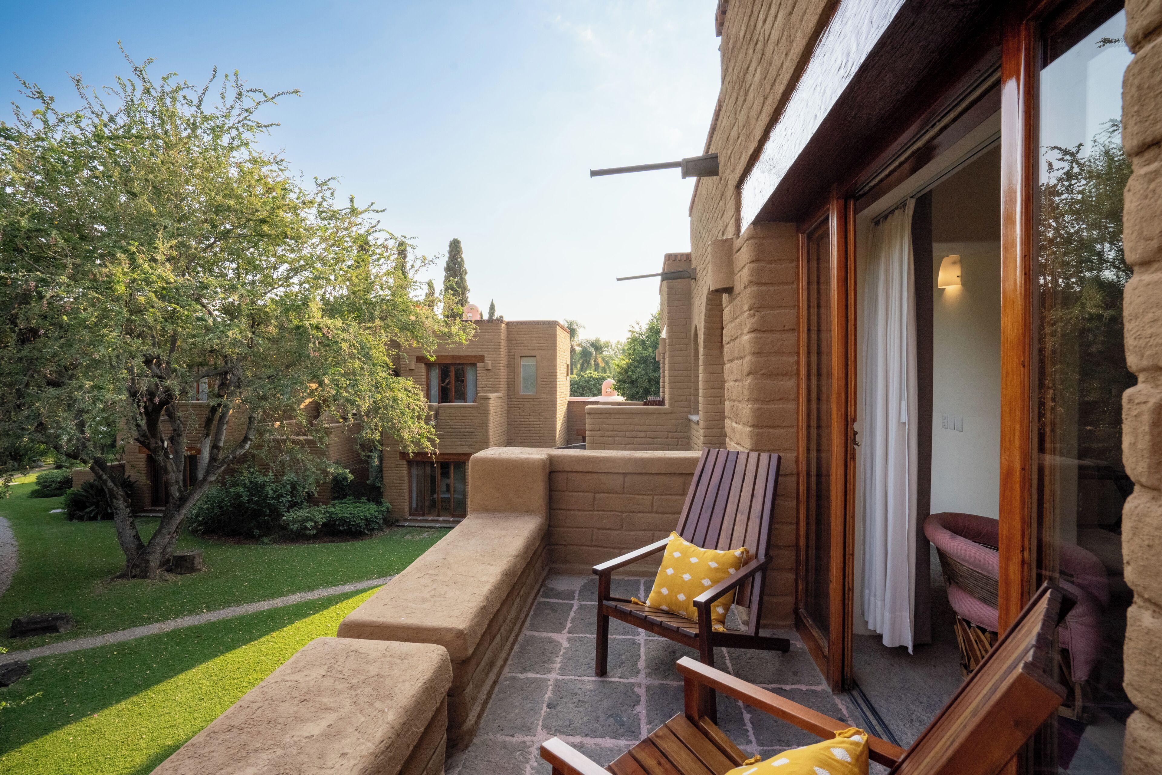 A patio with outdoor furniture, a stone pathway, and a building with a brick facade.
