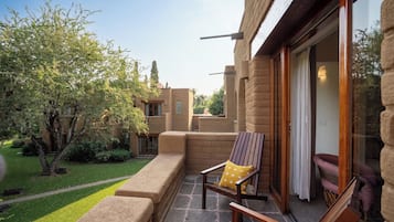 A patio with outdoor furniture, a stone pathway, and a building with a brick facade.