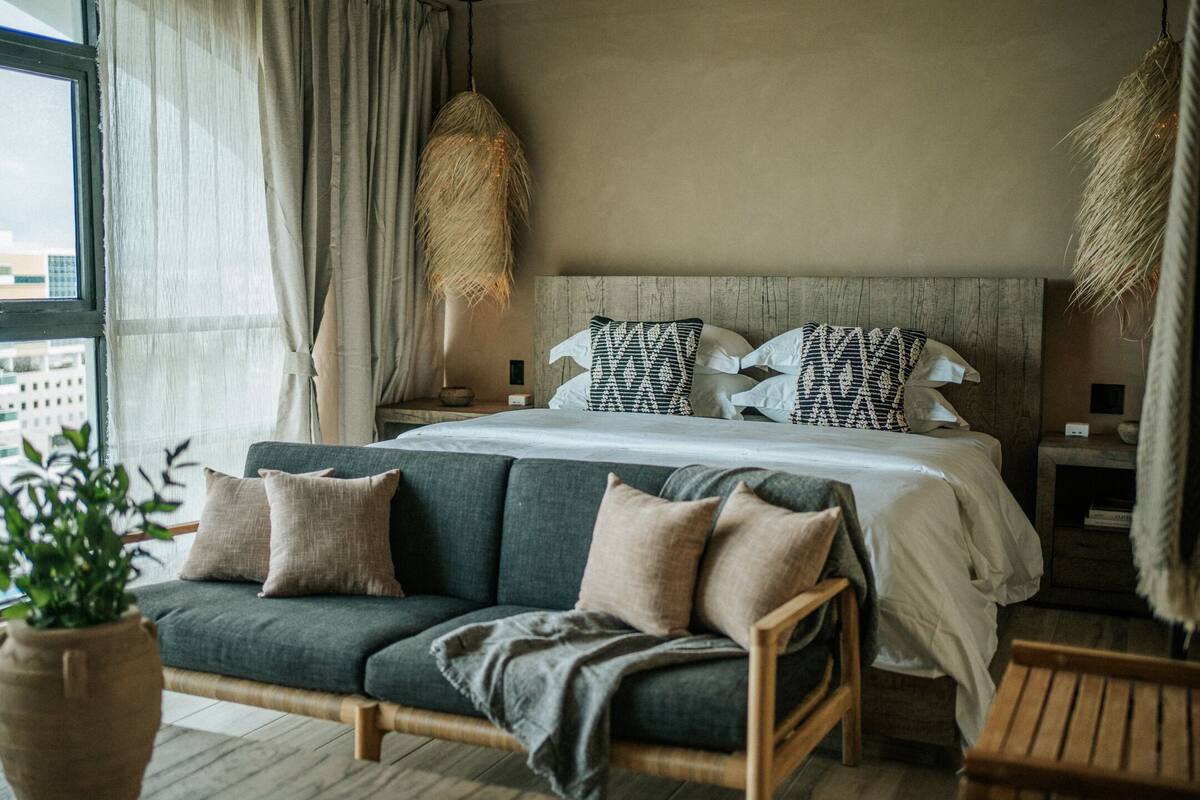 Une chambre à coucher moderne avec un grand lit, un canapé et une table de chevet.