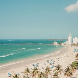 Na praia, espreguiçadeiras, guarda-sóis, toalhas de praia