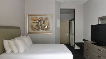 Relax in a serene space with a comfortable bed, flat-screen TV, and a stylish dresser.
