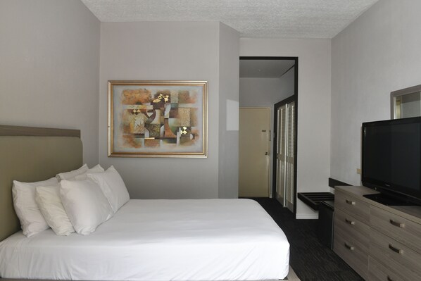 Relax in a serene space with a comfortable bed, flat-screen TV, and a stylish dresser.