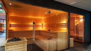 Un sauna avec des bancs en bois et une paroi en verre.