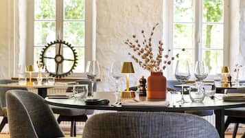 A dining area with a round table set for a meal, surrounded by chairs.