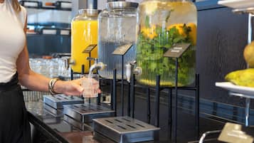 Eine Getränkespenderstation mit verschiedenen Optionen, darunter ein klares Glas und ein Glas mit gelber Flüssigkeit.