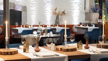 Um restaurante com mesas preparadas para refeições, velas e objetos decorativos.