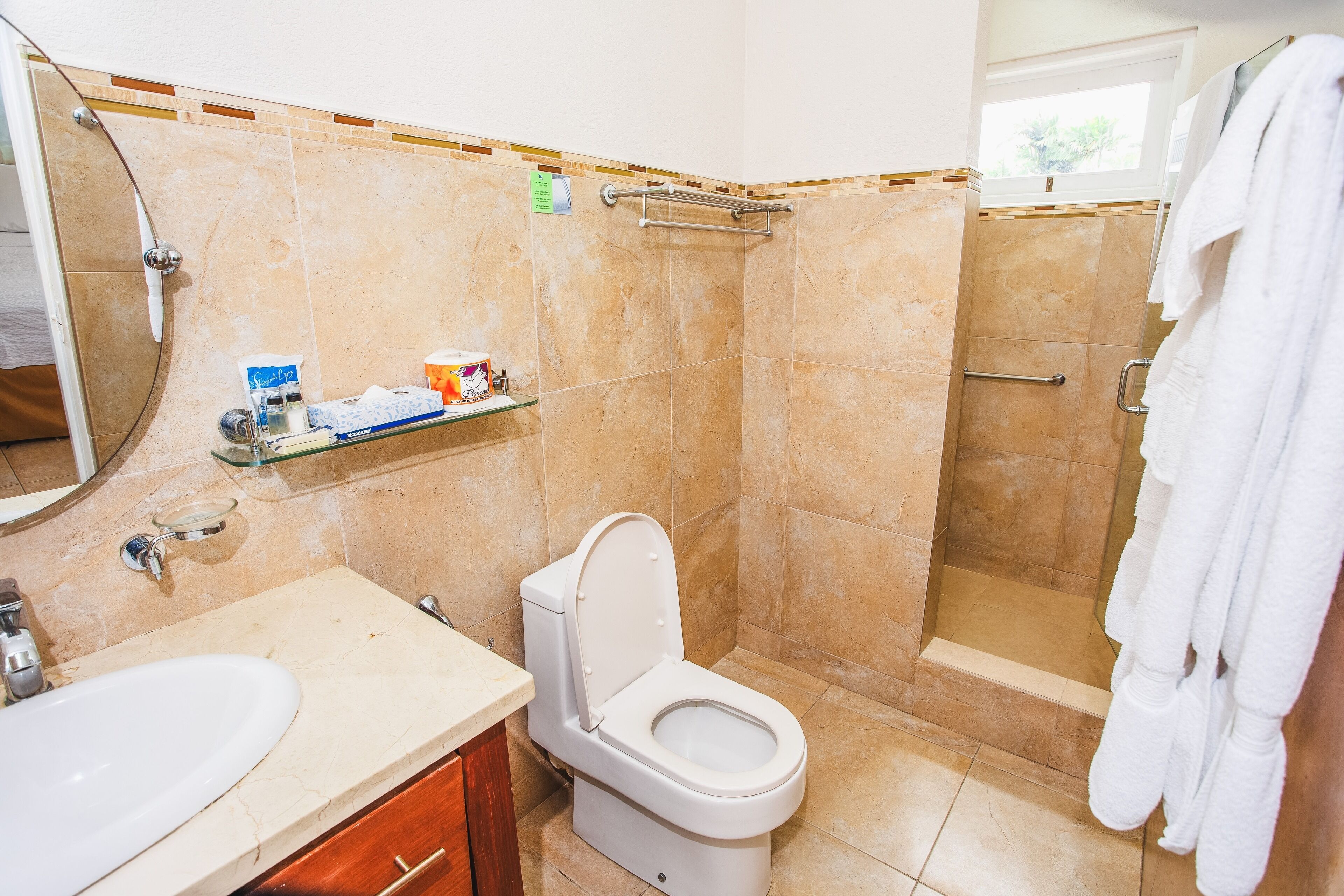 A bathroom with a toilet, sink, and shower area.