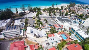 An aerial view of a coastal area with buildings, roads, and a beach.
