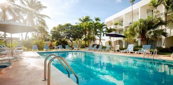 Una piscina al aire libre, sombrillas