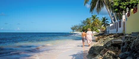 In Strandnähe, weißer Sandstrand, Liegestühle, Sonnenschirme