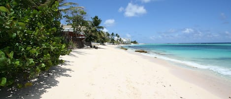 In Strandnähe, weißer Sandstrand, Liegestühle, Sonnenschirme