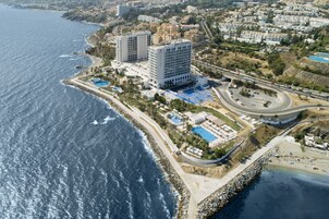 An aerial view of a coastal hotel with multiple buildings, a swimming pool, and a beach area.