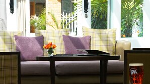 A cozy seating area with a sofa, a table, and a glass of beer. - Best Western Ship Hotel (Weybridge)