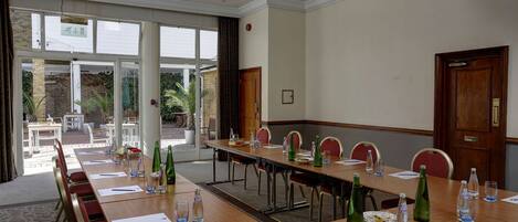 A conference room with a long table, chairs, and water bottles.