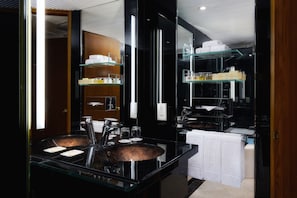 A modern bathroom with a glass sink, shelves with toiletries, and a mirror reflecting the space.