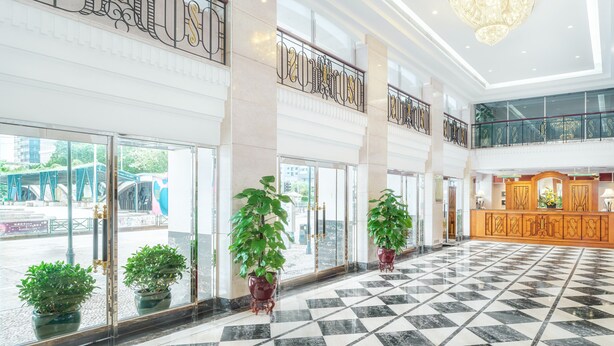 A spacious lobby with a checkered floor, large windows, and potted plants. - Hotel Sintra (Macau)
