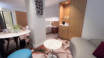 Merdeka Premier | Dundyner, senger med overmadrass, minibar og safe på rommet