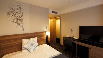 Una habitación de hotel con cama, escritorio, televisor y un adorno en la pared.