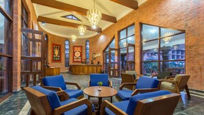 A lobby with brick walls, large windows, and wooden furniture.