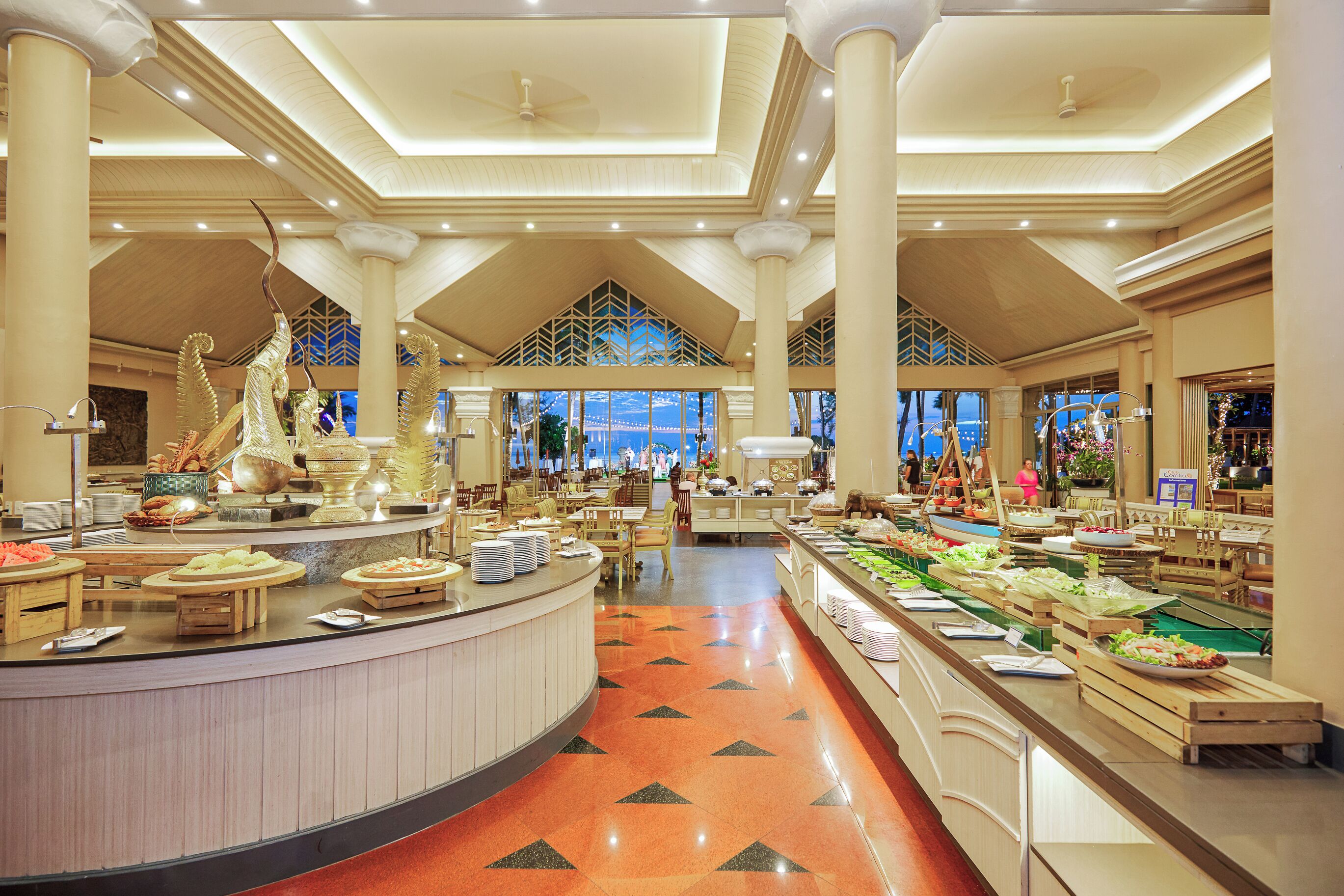 Un'ampia zona buffet con diverse postazioni gastronomiche e posti a sedere.