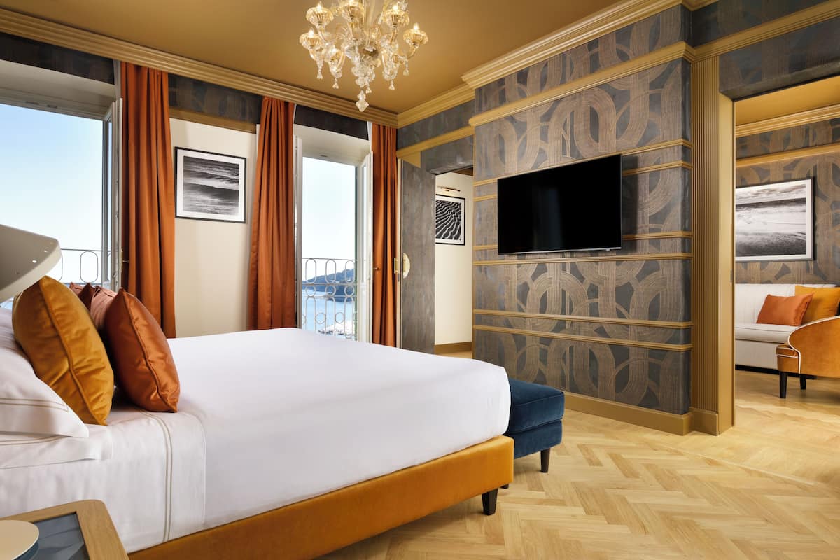 A hotel room with a large bed, a television, and a view of the outdoors.
