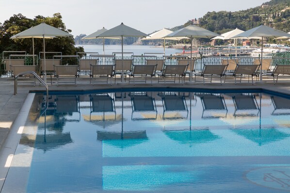 Una piscina al aire libre, tumbonas