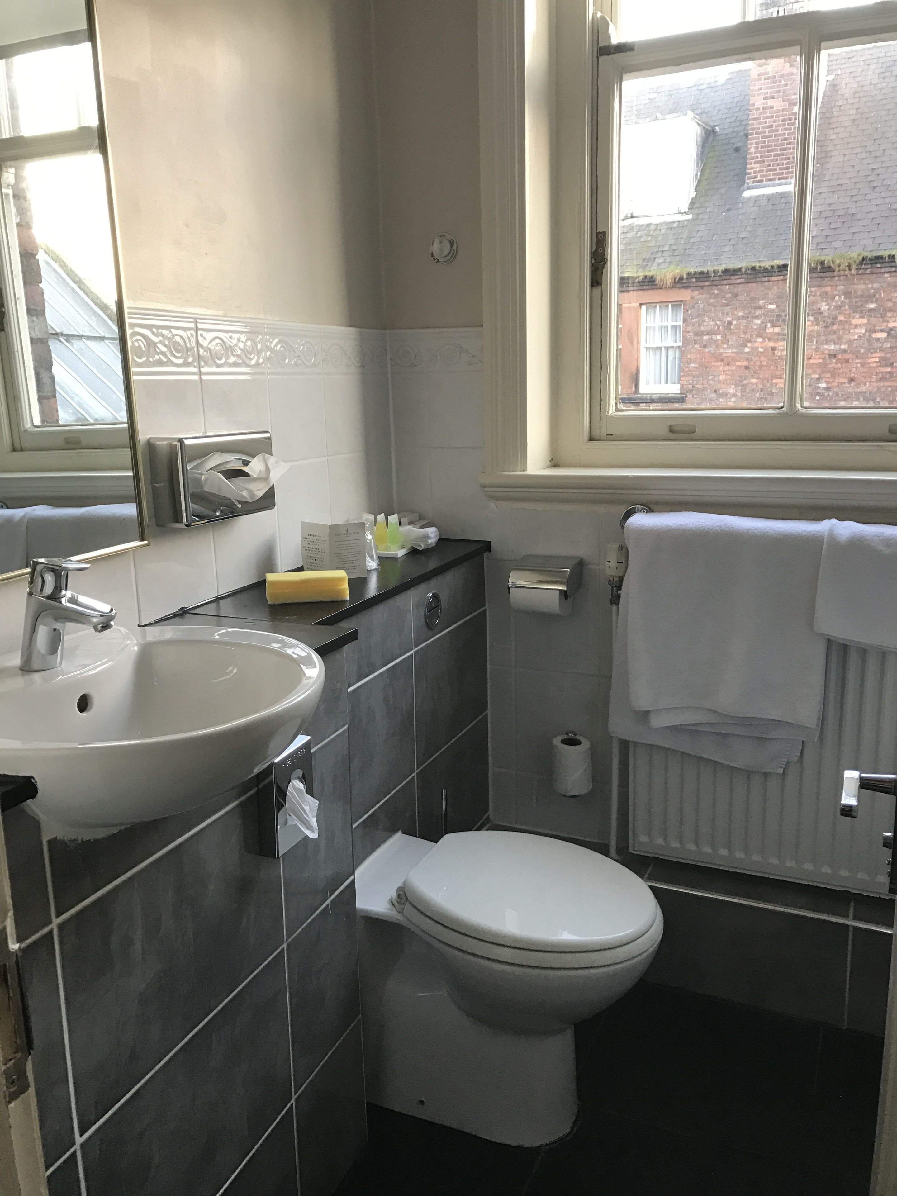 Un baño con lavabo, inodoro y ventana.