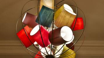 A ceiling light fixture with multiple cylindrical shades in various colors.