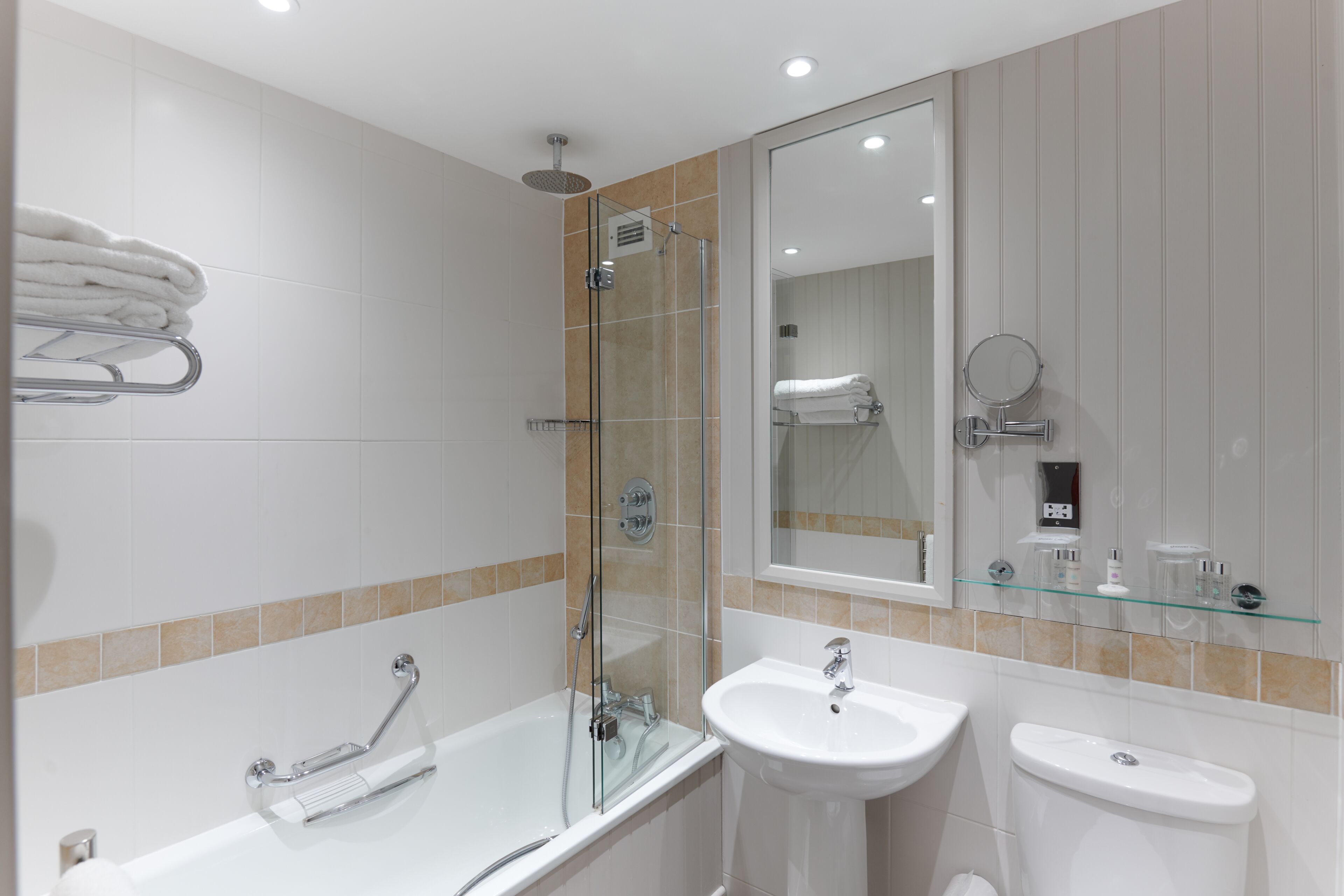 Une salle de bain moderne avec une douche à parois de verre, un lavabo blanc et des toilettes.