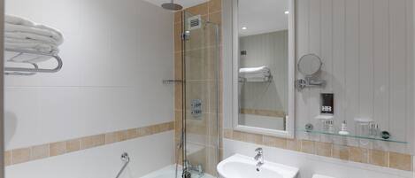 A modern bathroom with a glass-enclosed shower, a white sink, and a toilet.