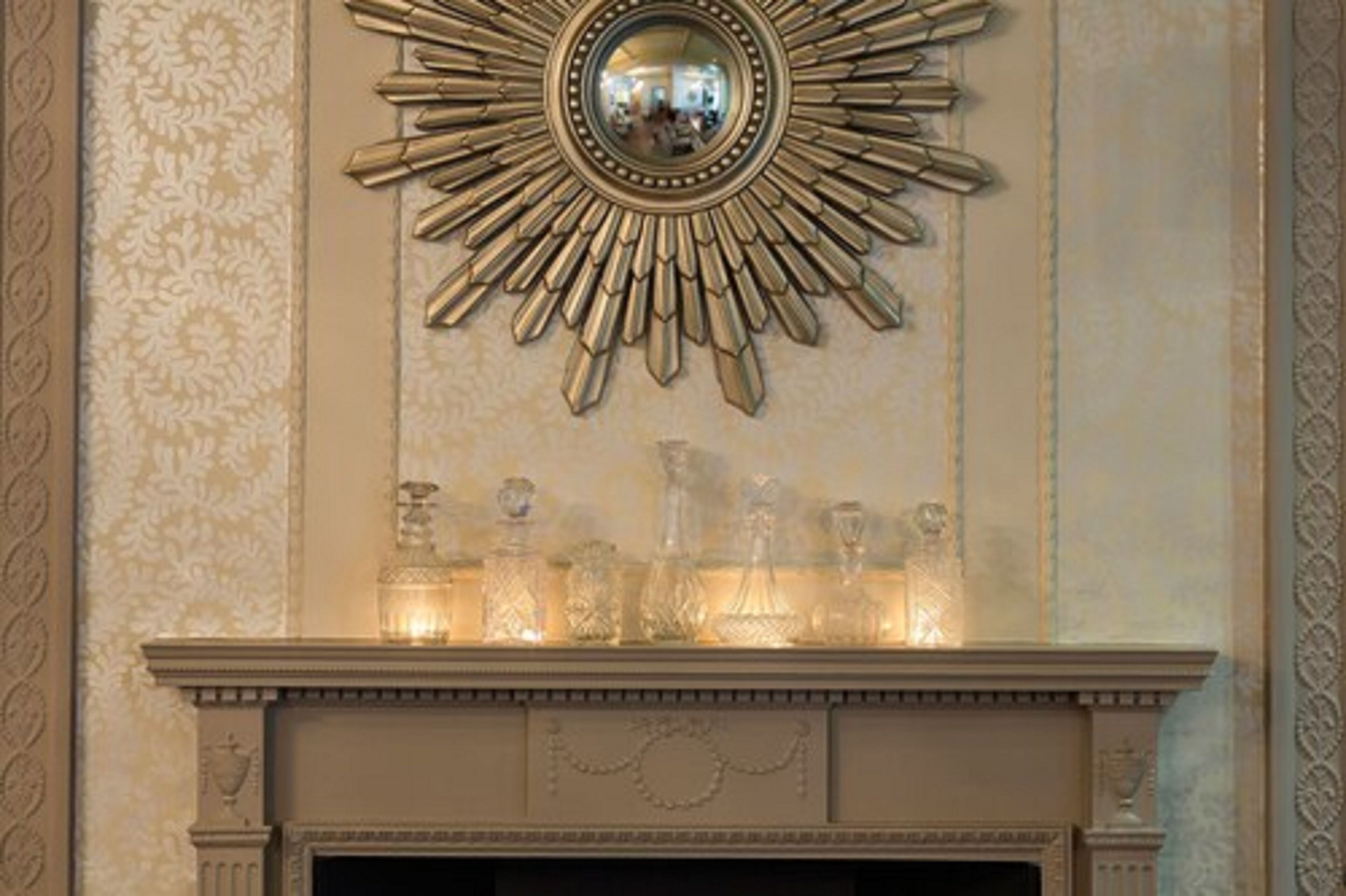 A fireplace with a decorative mirror above it.