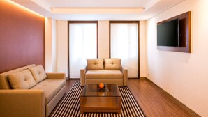 Una sala de estar moderna con un sofá, una mesa de centro y un televisor montado en la pared.