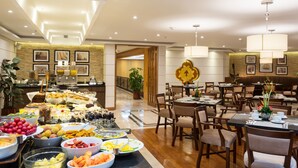 Comedor de hotel con bufé, mesas y decoración.