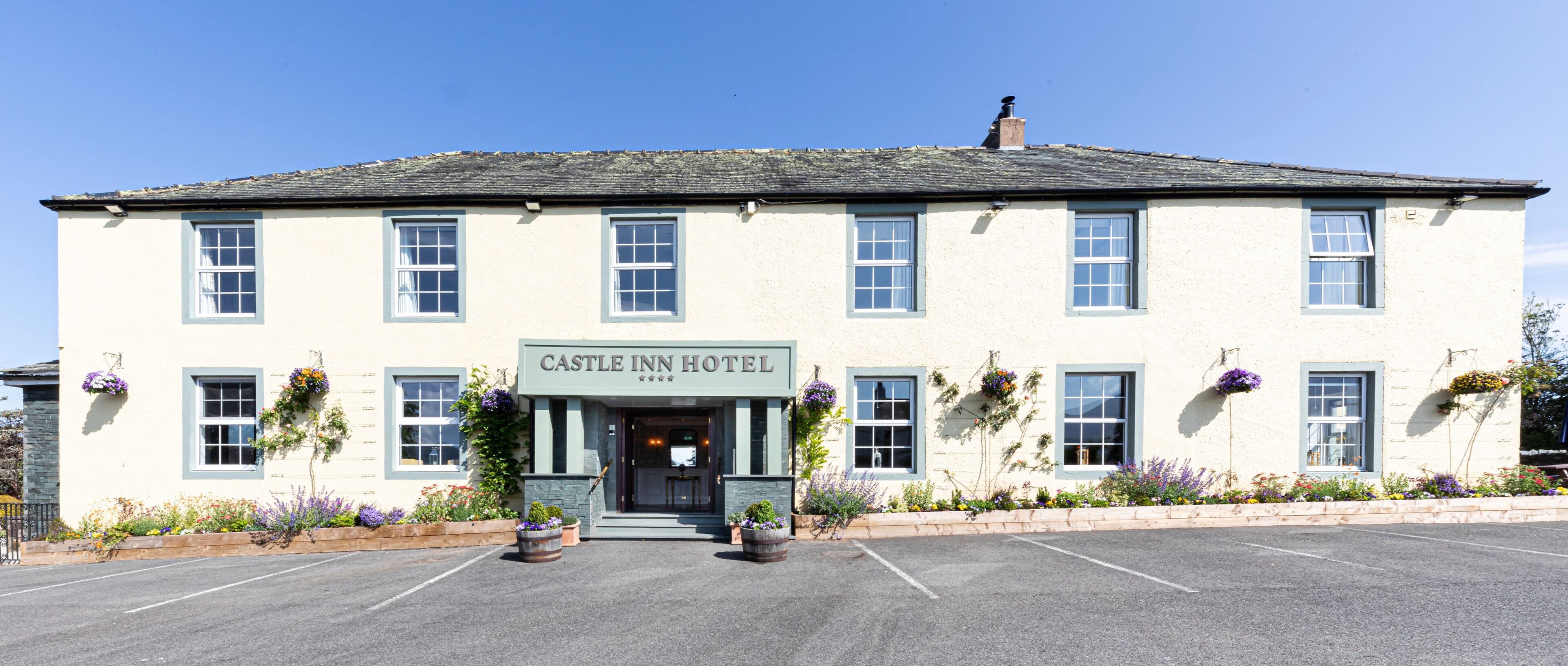 Un edificio de dos pisos con un letrero que dice 'CASTLE INN HOTEL'.