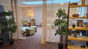 Una habitación acogedora con una cama, sillas, una mesa y plantas en macetas.