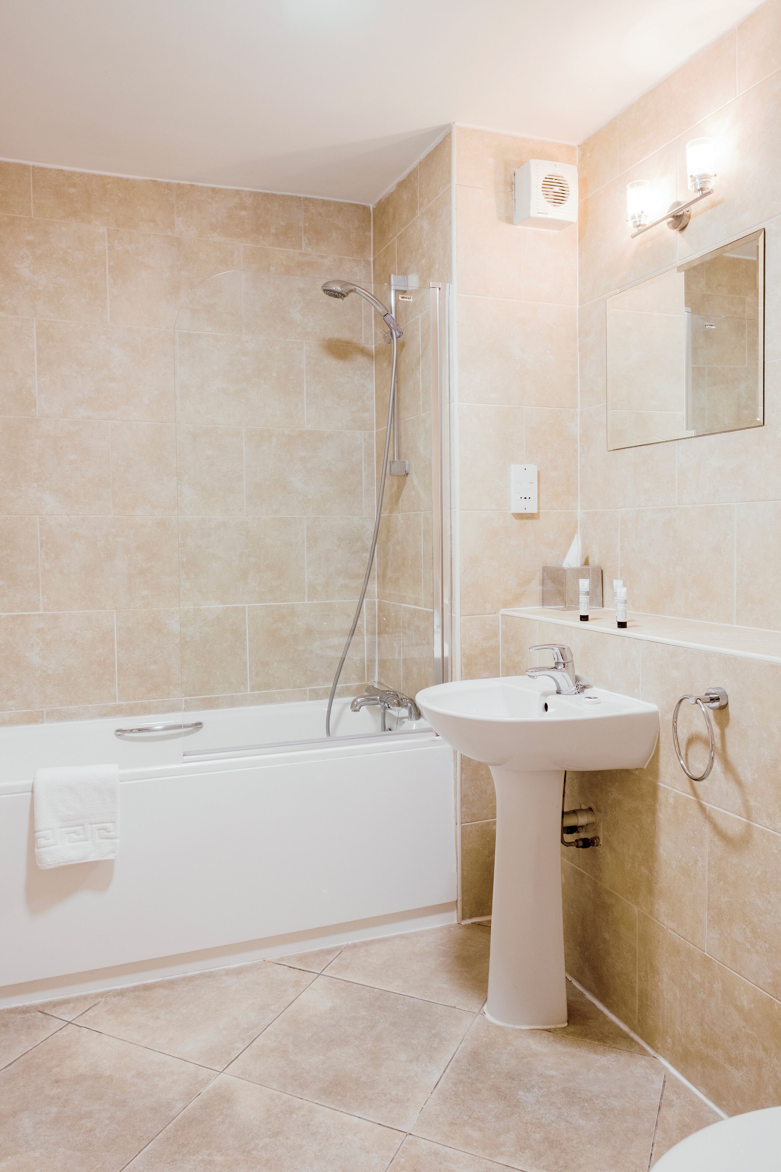 A modern bathroom with a bathtub, a sink, and a mirror.