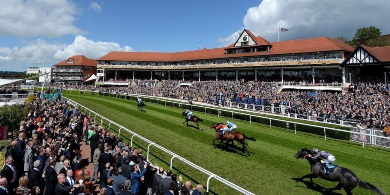 Un hippodrome avec des spectateurs et des jockeys.